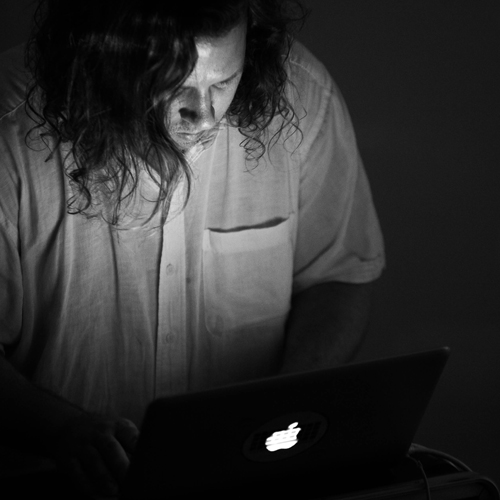 Dr Ogborn looking down at laptop in black and white